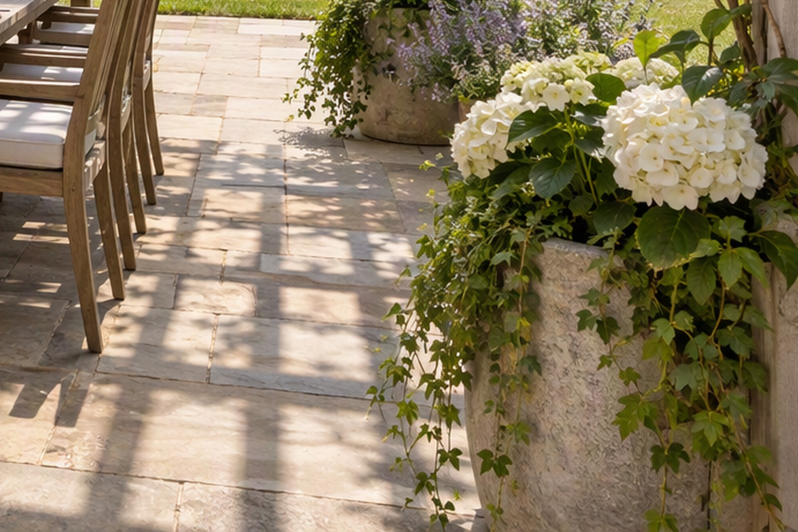 A finished stone patio with a dining area behind a house.