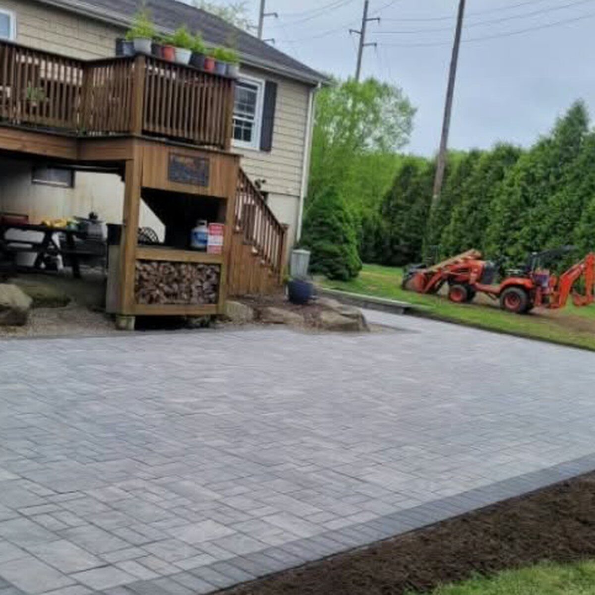 A two-level stone patio in front of a two-level wooden deck.