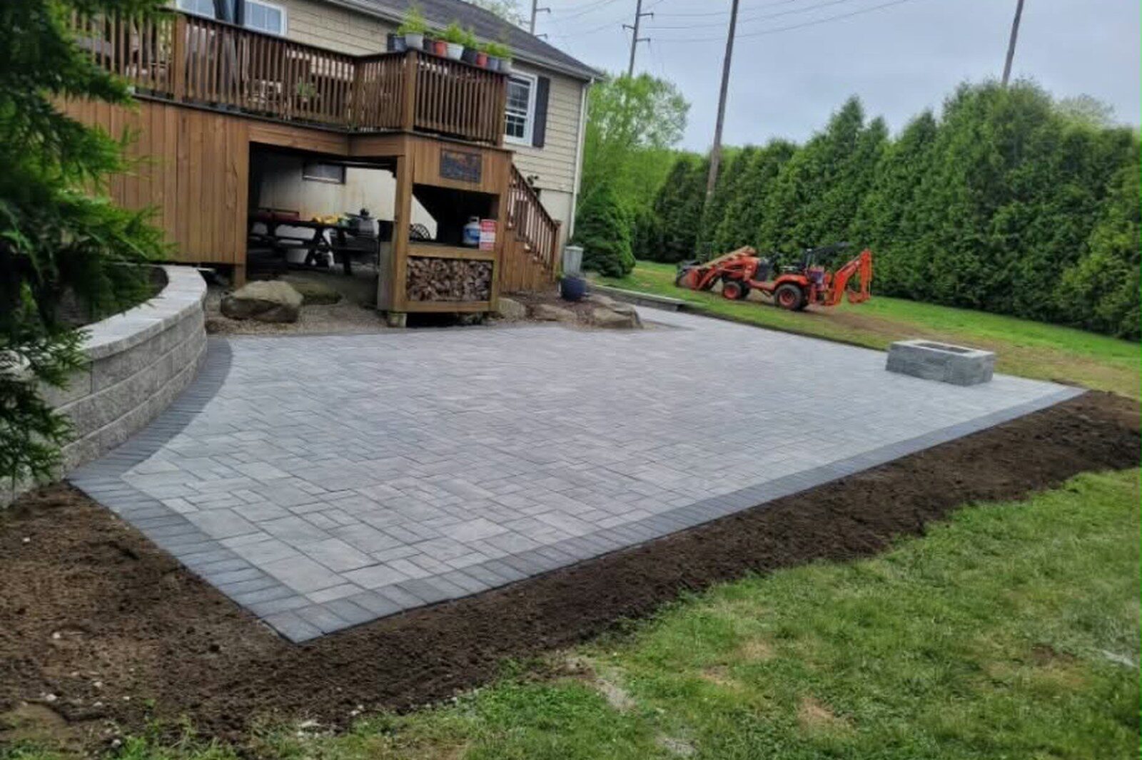 New pavers with a contrasting border curving into a low block wall.